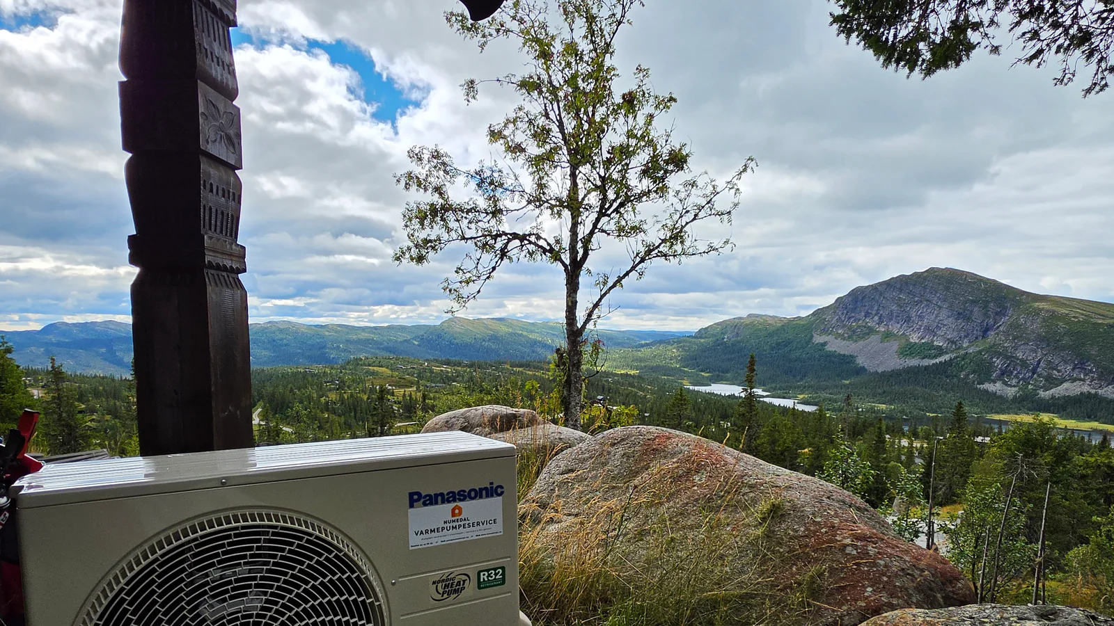 Panasonic utedel montert ved en hytte på Haglebu med fjell og vann i bakgrunnen