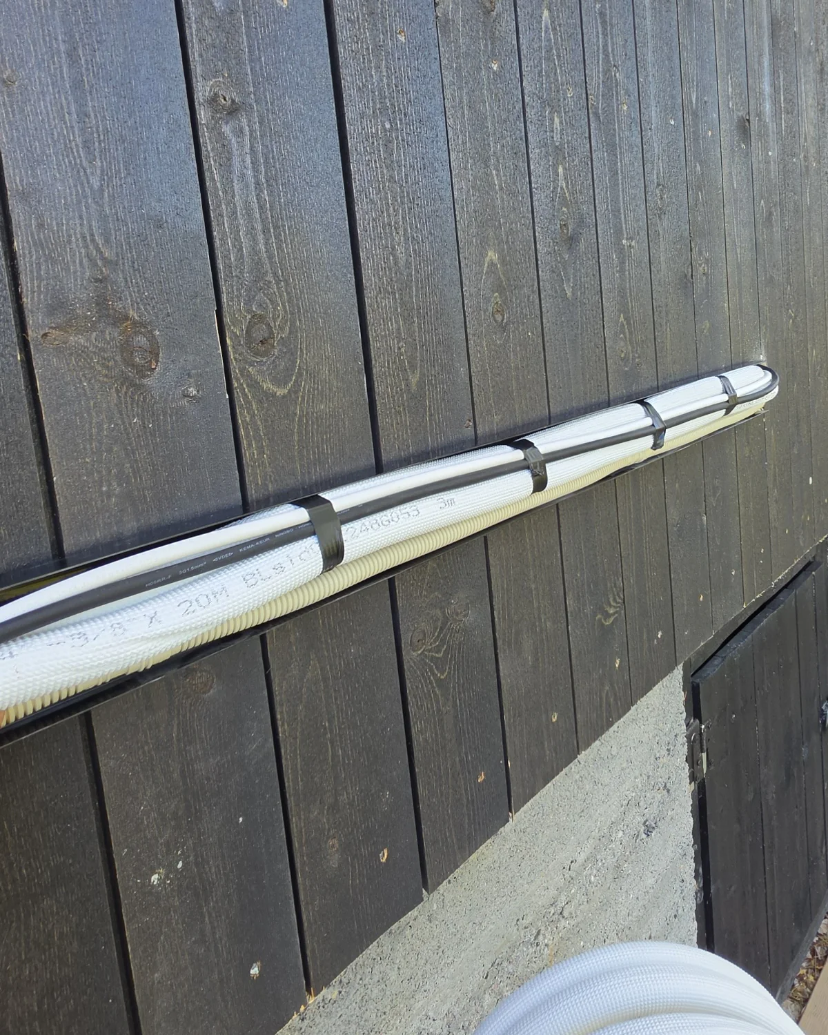 Isolerte rør og kabel fra Panasonic-varmepumpen under montering på en hytte i Lyngdal i Numedal